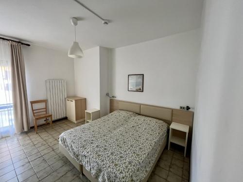 a bedroom with a bed and a chair at Residence Stella Maris in Pietra Ligure