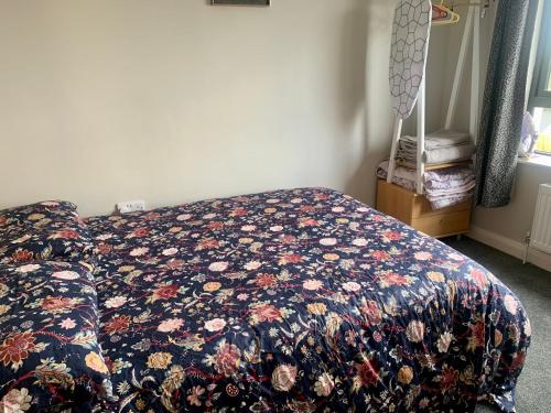 a bedroom with a bed with a floral comforter at Room with a view in Newry