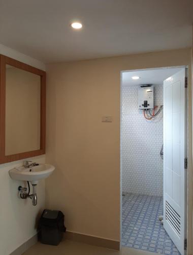 a bathroom with a sink and a mirror and a shower at BERYL HOMESTAY in Tarutung