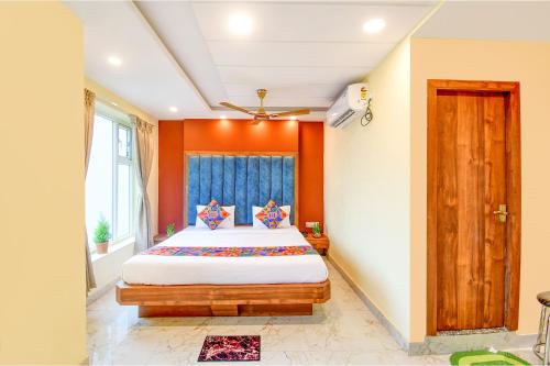 1 dormitorio con 1 cama grande y paredes de color naranja en FabHotel Aqua Tulip, en Calcuta