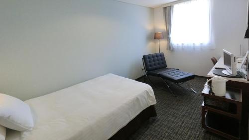 由利本莊市的住宿－Honjo Grand Hotel Vacation STAY 35748，酒店客房配有一张床、一张桌子和一把椅子。