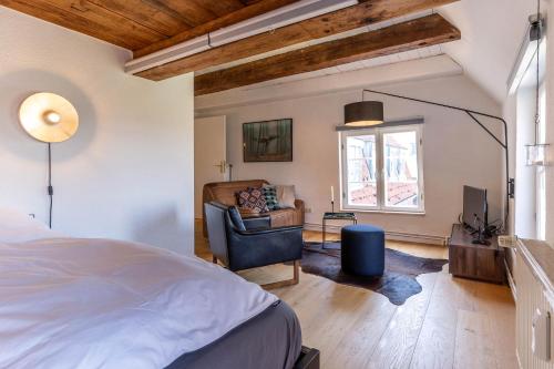 een slaapkamer met een bed, een stoel en een raam bij Dachstuv von Esmarch in Tönning