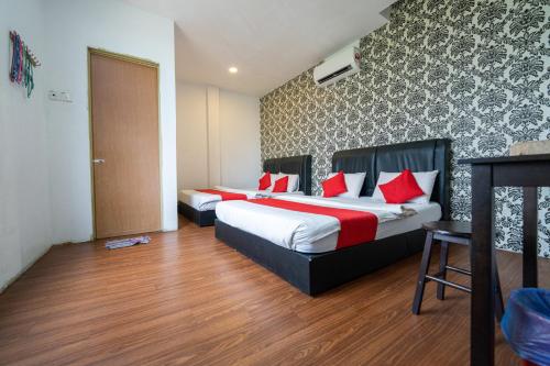 ein Hotelzimmer mit 2 Betten und roten Kissen in der Unterkunft MRJ Hotel Wakaf Che Yeh 2 in Kota Bharu