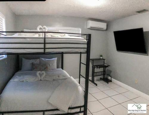 - une chambre avec des lits superposés et une télévision dans l'établissement Miami Private Family Home Apt 1, à Tamiami