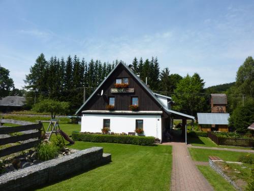 a small white house with a black roof at PENZION U ŠTEFANA in Ostružná