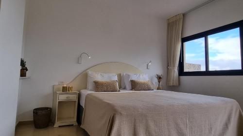 a bedroom with a large bed with a window at Desert Call in Arad