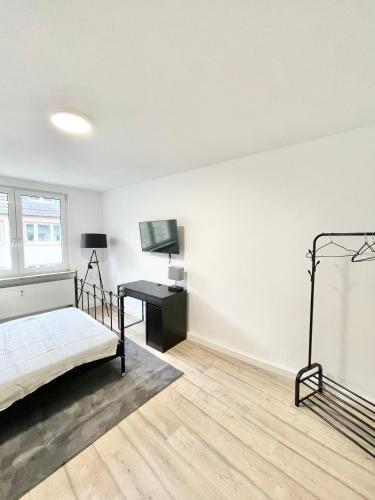 a white bedroom with a bed and a desk at City Loft in Toplage Mainz-Kastel in Wiesbaden