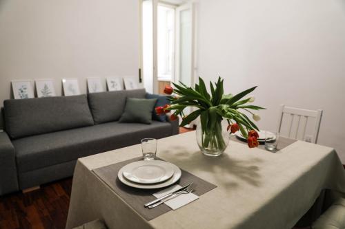 a living room with a table and a couch at Aura Home rent of rooms with shared kitchen in Bari