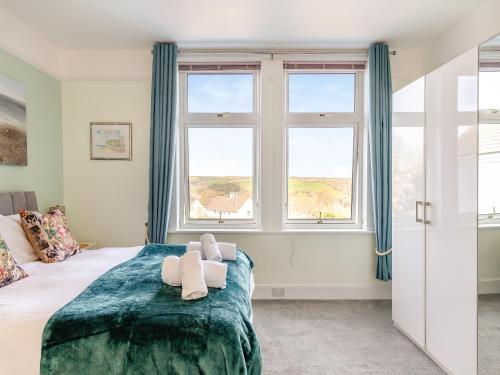 a bedroom with a bed and two windows at Number 10 in Dartmouth
