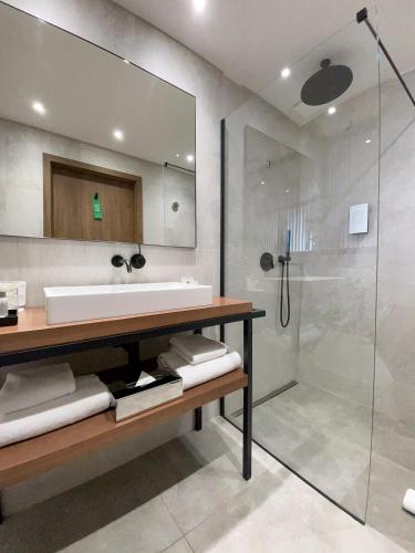 a bathroom with a sink and a shower at Golden Tulip Porto-Vecchio in Porto-Vecchio