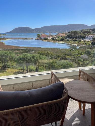 a balcony with a table and chairs and a view of the water at Golden Tulip Porto-Vecchio in Porto-Vecchio