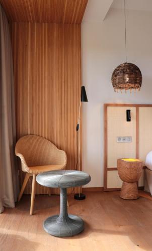 a room with a chair and a table and a lamp at Golden Tulip Porto-Vecchio in Porto-Vecchio