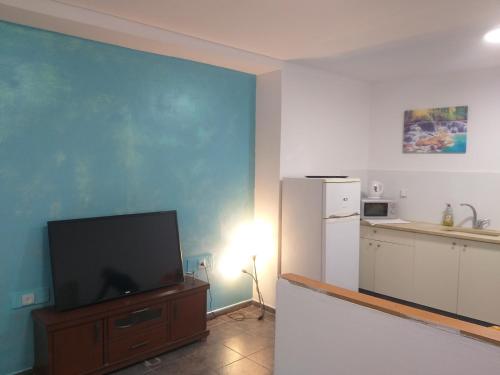 a living room with a television and a refrigerator at דירת נופש במרכז תיירות אילת in Eilat