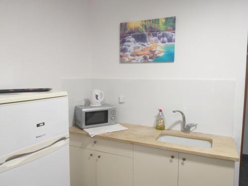 a kitchen with a sink and a microwave at דירת נופש במרכז תיירות אילת in Eilat