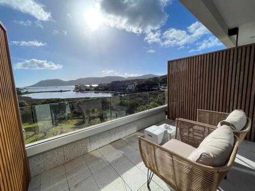 a balcony with a chair and a view of the ocean at Golden Tulip Porto-Vecchio in Porto-Vecchio