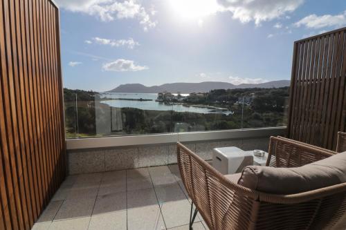 a balcony with a view of a body of water at Golden Tulip Porto-Vecchio in Porto-Vecchio