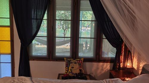 - une chambre avec un lit et 2 fenêtres dans l'établissement Cassiopeia Srithanu Apartments, à Srithanu