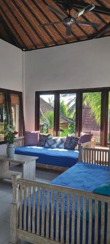 a bedroom with two beds and a bench in a room at Villa Gede Private Guest House in Selemadeg