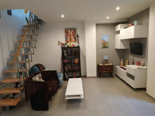 - un salon avec un escalier, un canapé et une table dans l'établissement Maison de ville à 10 minutes de Paris, à Nanterre