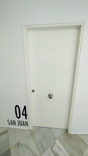 a white door with a sign on it in a room at Apartamentos GADIR CENTRO in Cádiz