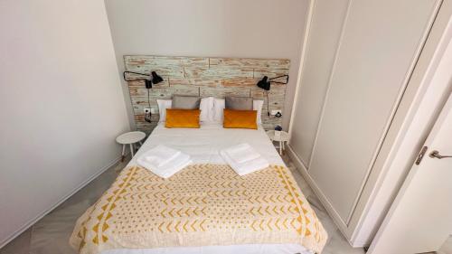 a bedroom with a large bed with orange pillows at Apartamentos GADIR CENTRO in Cádiz