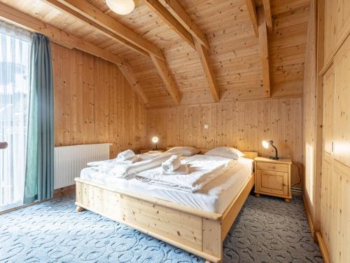 ザンクト・ローレンツェン・オプ・ムーラウにあるModern Holiday Home in Sankt Georgen with Swimming Poolの木製の部屋に大型ベッドが備わるベッドルーム1室が備わります。