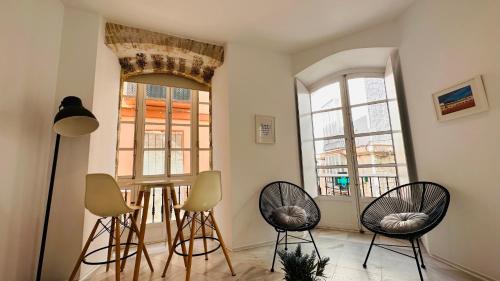 Habitación con 3 sillas y 2 ventanas en Apartamentos GADIR CENTRO, en Cádiz