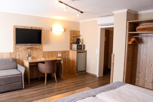 a room with a bed and a kitchen with a desk at Hotel & Restaurant Zum Reussenstein in Böblingen