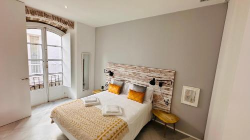 Un dormitorio con una cama grande y una ventana en Apartamentos GADIR CENTRO, en Cádiz
