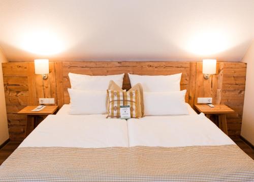 a bedroom with a large white bed with two lamps at Hotel & Restaurant Zum Reussenstein in Böblingen