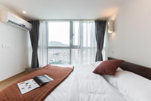 a bedroom with a bed with a large window at WESU Apartment Shenzhen Futian Bagualing Branch in Shenzhen