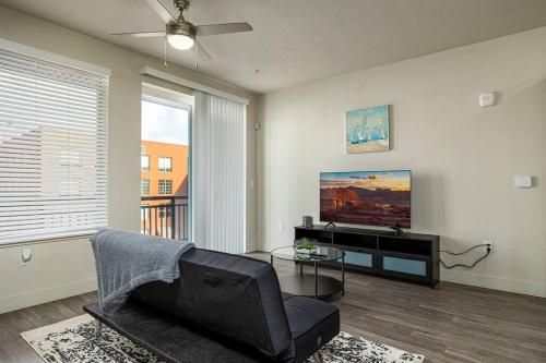 a living room with a couch and a tv at Modern 1B Downtown SLC with WFH Setup, Gym, Fast Wi-Fi, Pool in Salt Lake City