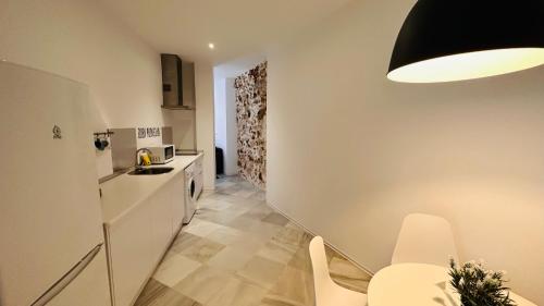 a small kitchen with a sink and a table at Apartamentos GADIR CENTRO in Cádiz