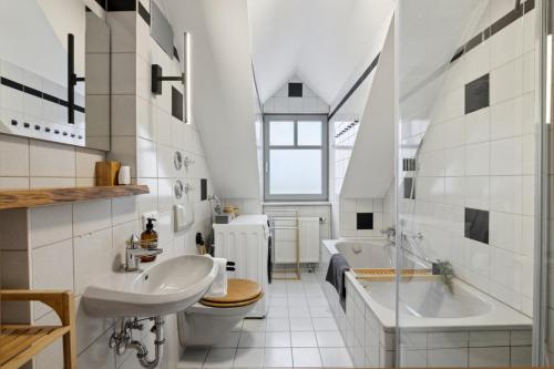 a bathroom with a sink and a tub and a toilet at smooth living Apartments Augsburg Lechhausen - Free parking in Augsburg