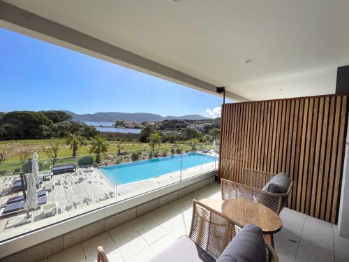 a balcony with a view of a swimming pool at Golden Tulip Porto-Vecchio in Porto-Vecchio