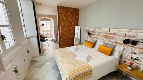a bedroom with a bed with a wooden headboard at Apartamentos GADIR CENTRO in Cádiz