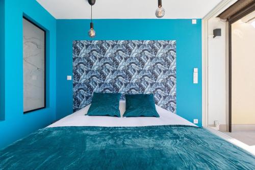 - une chambre bleue avec un lit et 2 oreillers bleus dans l'établissement Village Naturiste R4N - Le Bellagio Héliopolis Luxe, au Cap d'Agde