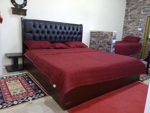 1 dormitorio con 1 cama grande con colcha roja en family studio en Wadi Musa