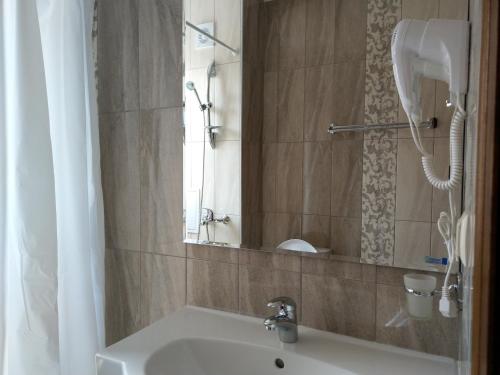a bathroom with a white sink and a shower at Апартаменти Детелини in Primorsko