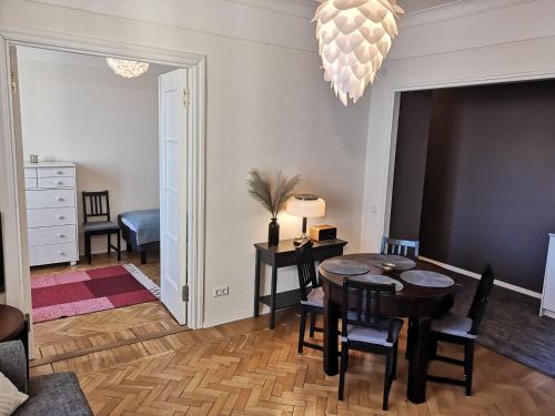 塔林的住宿－Gonsiori 3 Tenors Apartment，客厅配有桌椅和吊灯。
