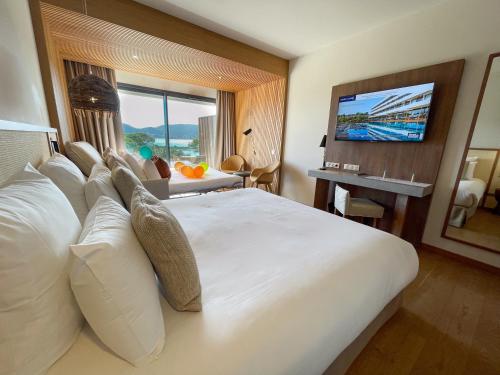a hotel room with a large bed and a television at Golden Tulip Porto-Vecchio in Porto-Vecchio