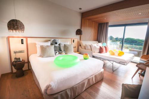 a bedroom with a large bed with a dog sitting on it at Golden Tulip Porto-Vecchio in Porto-Vecchio
