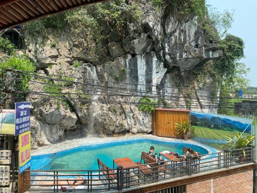 una piscina di fronte a una parete di roccia di Bamboo Hill Villa a Ninh Binh