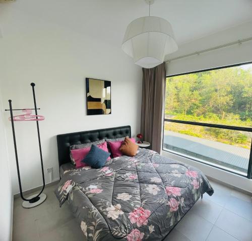 ein Schlafzimmer mit einem Bett und einem großen Fenster in der Unterkunft The Grand Homestay ッ in Sandakan