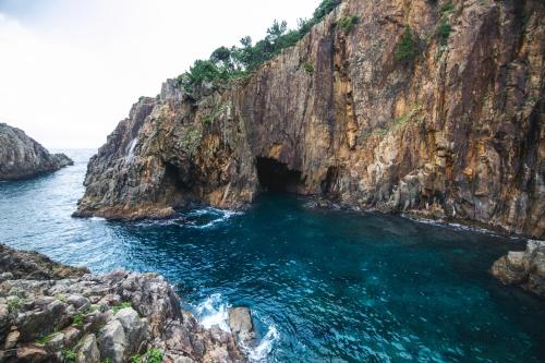 a cave in the side of a rocky cliff at TheMana Village in Tosashimizu