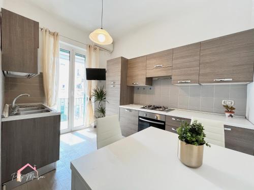 a kitchen with wooden cabinets and a white counter top at Patty Maison - Large & New Central Apartment in Bari