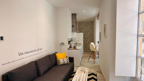 a living room with a couch and a kitchen at Apartamentos GADIR CENTRO in Cádiz