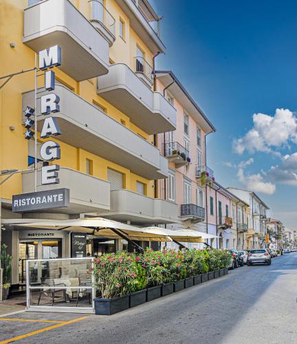 a yellow building with a sign on the side of a street at Hotel Mirage in Viareggio