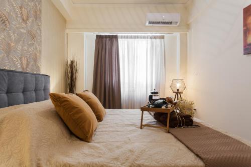 a bedroom with a bed with a table and a window at Lovely renovated apartment walk to Acropolis in Athens