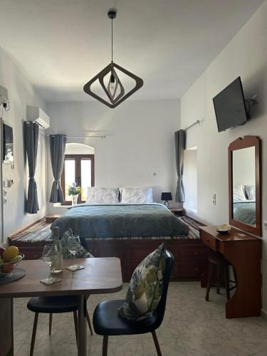 a bedroom with a bed and a table and a mirror at New Lindos Studio 45 renovated in Lindos